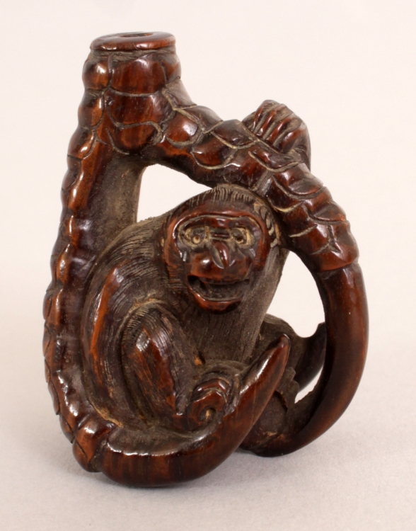 Monkey Seated within dragon's claw netsuke
